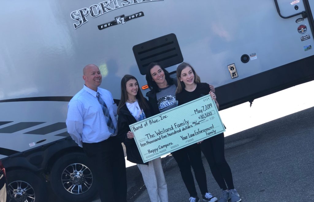 The Weiland family receives a camper and a check.